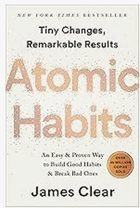 Book cover of Atomic Habits by James Clear, white with gold dotted typography.